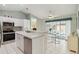 Well-lit kitchen with white cabinetry, stainless steel appliances, and a breakfast nook overlooking the pool area at 1110 Southlake Ct, Venice, FL 34285