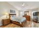 Comfortable bedroom with hardwood floors, ceiling fan, ensuite bath, and natural light at 1110 Southlake Ct, Venice, FL 34285