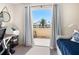 Bedroom features a balcony with blue and white curtains, overlooking palm trees and a sunny sky at 1164 Beachcomber Ct # 19, Osprey, FL 34229