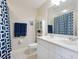 Bright bathroom features double sink, white cabinets, and blue patterned shower curtain at 1164 Beachcomber Ct # 19, Osprey, FL 34229