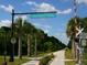 The Legacy Trail entrance with palm trees, showcasing a scenic paved pathway at 1164 Beachcomber Ct # 19, Osprey, FL 34229