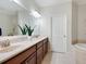 Ensuite bathroom features double sink vanity, soaking tub, tile floors, and ample counter space at 1164 Beachcomber Ct # 19, Osprey, FL 34229