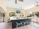 Outdoor kitchen with bar seating, stainless grill, arched openings, and views of residences at 1164 Beachcomber Ct # 19, Osprey, FL 34229