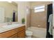 Well-lit bathroom featuring wood cabinets, vanity, tiled shower and tub combination at 11954 Tempest Harbor Loop, Venice, FL 34292