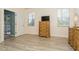 Bright bedroom featuring wood-look flooring, natural light, and closet access at 11954 Tempest Harbor Loop, Venice, FL 34292