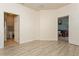 Spacious room featuring wood-look flooring, neutral walls, and access to bathroom and living room at 11954 Tempest Harbor Loop, Venice, FL 34292