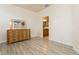 Bright bedroom featuring wood-look flooring, neutral walls, wooden dresser and bathroom access at 11954 Tempest Harbor Loop, Venice, FL 34292