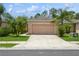 Charming single-story home with a well-manicured lawn, palm trees and a two-car garage at 11954 Tempest Harbor Loop, Venice, FL 34292