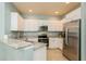 Bright kitchen featuring stainless steel appliances and ample white cabinetry and counter space at 11954 Tempest Harbor Loop, Venice, FL 34292
