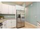 Spacious kitchen with stainless steel refrigerator, granite countertops and white cabinets at 11954 Tempest Harbor Loop, Venice, FL 34292