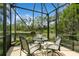 Screened patio with table and seating overlooking lush greenery and pond at 11954 Tempest Harbor Loop, Venice, FL 34292