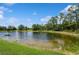 Scenic view of a beautiful pond with lush green trees and landscape at 11954 Tempest Harbor Loop, Venice, FL 34292