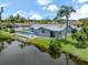 Waterfront home with a screened pool and lush landscaping with view of the canal at 120 Hourglass Dr, Venice, FL 34293