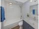 Bathroom featuring tub and shower combo with single sink vanity and blue shaker cabinets at 120 Hourglass Dr, Venice, FL 34293