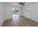Bedroom featuring wood floors, ceiling fan and sliding glass door access to the pool at 120 Hourglass Dr, Venice, FL 34293