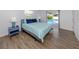 Bright bedroom features wood floors, a bed with light blue bedding and sliding glass doors leading to the pool at 120 Hourglass Dr, Venice, FL 34293
