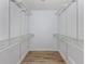 Walk-in closet with wood floor and plenty of shelving and hanging storage at 120 Hourglass Dr, Venice, FL 34293