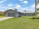 Inviting single-story home with a well-manicured lawn and gray stone accents and attached two car garage at 120 Hourglass Dr, Venice, FL 34293
