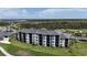 An aerial view showcases a luxury condominium complex adjacent to a pristine golf course at 12140 Wellen Golf St # 202, Venice, FL 34293