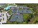 A birds-eye view showing the community tennis courts and pool, surrounded by vibrant green landscaping at 12140 Wellen Golf St # 202, Venice, FL 34293