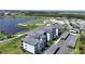 A birdseye view showcases a luxury condominium complex adjacent to a pristine golf course and lake at 12140 Wellen Golf St # 202, Venice, FL 34293