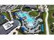 Aerial view of the community pool and amenities featuring a spacious deck, cabanas, and lush landscaping at 12140 Wellen Golf St # 202, Venice, FL 34293