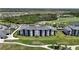 An aerial view showcases a luxury condominium complex adjacent to a pristine golf course at 12140 Wellen Golf St # 202, Venice, FL 34293