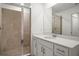 Bathroom featuring tiled shower, white cabinets and a mirror at 12140 Wellen Golf St # 202, Venice, FL 34293