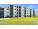 Well-maintained condo building with screened lanais and manicured green lawn at 12140 Wellen Golf St # 202, Venice, FL 34293