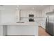 Bright kitchen features an island, stainless steel appliances, and modern white cabinets at 12140 Wellen Golf St # 202, Venice, FL 34293