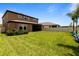 Large fenced backyard featuring manicured lawn, lush green landscaping, and a contemporary two-story home at 12617 Oak Hill Way, Parrish, FL 34219