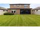 Well-maintained lawn in the backyard, showcasing the home's exterior and the privacy fence at 12617 Oak Hill Way, Parrish, FL 34219