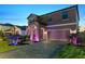 Home exterior featuring lovely landscaping, paved driveway, a two-car garage, and stylish accent lighting at 12617 Oak Hill Way, Parrish, FL 34219