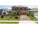 Beautiful two-story home featuring a manicured lawn, brick-paved driveway, and attached two-car garage at 12617 Oak Hill Way, Parrish, FL 34219