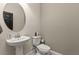 Neutral powder room features a pedestal sink, round mirror and a modern toilet at 12617 Oak Hill Way, Parrish, FL 34219