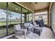 Outdoor seating area with ceiling fan on screened porch with view of fenced backyard with green grass at 12617 Oak Hill Way, Parrish, FL 34219