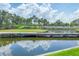 Backyard featuring a pond, mature trees, and an idyllic bridge connecting the landscape at 1345 Reserve Dr, Venice, FL 34285