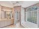 Bright bathroom with tiled floor, shower, soaking tub, and decorative wallpaper at 1345 Reserve Dr, Venice, FL 34285