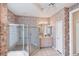 Well-lit bathroom with floral wallpaper, glass shower, and white tiled floors at 1345 Reserve Dr, Venice, FL 34285