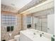 Bathroom featuring floral wallpaper, shower, and large mirror with bright lighting at 1345 Reserve Dr, Venice, FL 34285