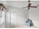 Neutral bedroom with a ceiling fan, chair, window with blinds, and closet with folding doors at 1345 Reserve Dr, Venice, FL 34285