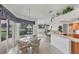 Bright kitchen with a glass table, tiled floors, and large windows overlooking the backyard and the golf course at 1345 Reserve Dr, Venice, FL 34285