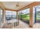 Screened-in patio with a ceiling fan, a table with four chairs, and views of the backyard at 1345 Reserve Dr, Venice, FL 34285