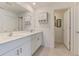 Bright bathroom featuring double sinks, white cabinets, and a large mirror at 137 Hercules Dr, Rotonda West, FL 33947