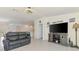 Comfortable living room with a gray couch, media center, and light colored flooring at 137 Hercules Dr, Rotonda West, FL 33947