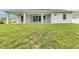 A large, grassy backyard with a covered patio extending the living space at 137 Mariner Ln, Rotonda West, FL 33947