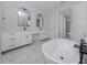 Luxurious bathroom with double vanity, soaking tub, and black hardware accents at 137 Mariner Ln, Rotonda West, FL 33947