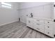 A practical laundry room with ample storage, gray wood-look flooring, and sink at 137 Mariner Ln, Rotonda West, FL 33947