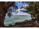 Picturesque water view framed by trees, showcasing a boat sailing on calm, clear waters at 137 Mariner Ln, Rotonda West, FL 33947