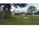 Spacious backyard featuring a pool area with fencing, mature trees, and ample green space at 14261 Palm Ter, Port Charlotte, FL 33953